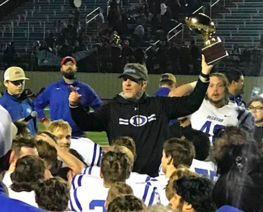 Photo courtesy of Carrie Alano

Pictured: Coach Mike Fuller giving a talk to his team after victory against Hirschi 