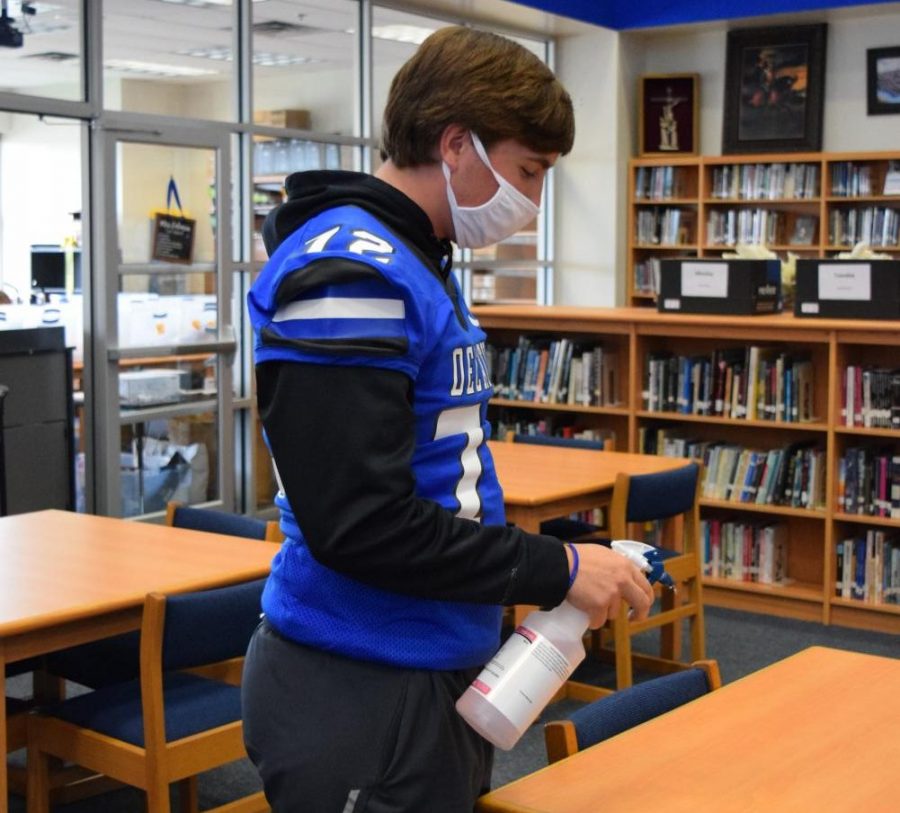 Senior library aide, Alec Burdge helps maintain clean surfaces for students using the library  throughout the day. 